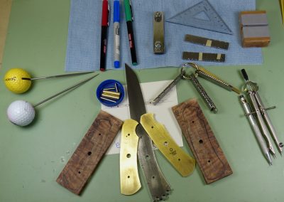 Knife blank with materials and tools on work bench