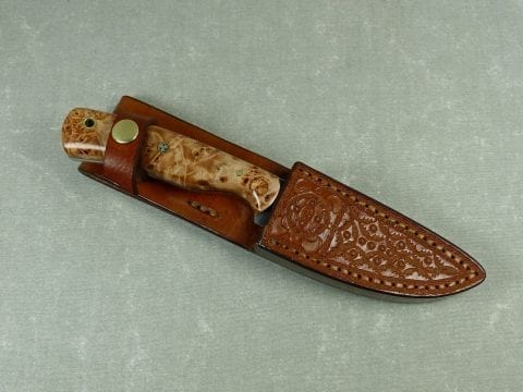 SW2 burled maple stonewashed knife inserted into handmade leather sheath